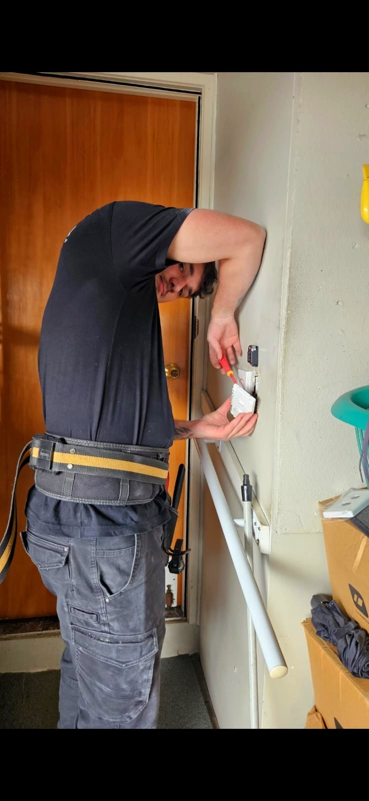 An electrician replacing a wall unit at a customer's home